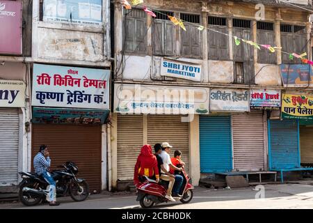 Bhopal, Madhya Pradesh, Indien - März 2019: Eine indische vierköpfige Familie fährt auf einem Roller auf den Marktstraßen der Altstadt von Bhopal. Stockfoto