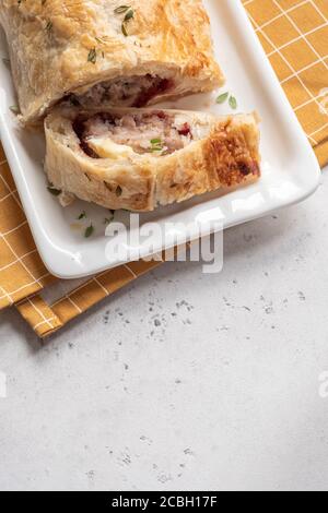 Gebackene Schweinefleisch putenwurstbrötchen mit Brie-Käse und Cranberry Sauce in Blätterteig Stockfoto