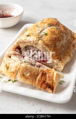 Gebackene Schweinefleisch putenwurstbrötchen mit Brie-Käse und Cranberry Sauce in Blätterteig Stockfoto