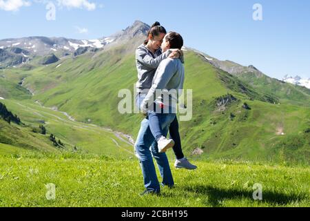 Seitenansicht Des Mannes, Der Frau In Den Bergen In Österreich Hebt Stockfoto