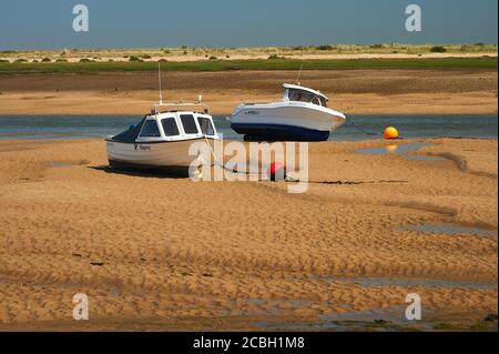 Boote entlang der Sandbänke, die bei Ebbe bei Wells next the Sea, Norfolk, erstellt wurden Stockfoto