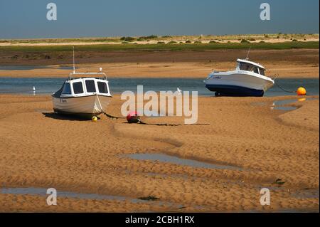 Boote entlang der Sandbänke, die bei Ebbe bei Wells next the Sea, Norfolk, erstellt wurden Stockfoto