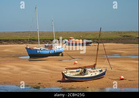 Boote entlang der Sandbänke, die bei Ebbe bei Wells next the Sea, Norfolk, erstellt wurden Stockfoto