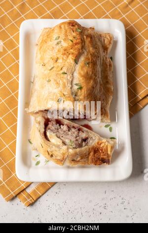 Gebackene Schweinefleisch putenwurstbrötchen mit Brie-Käse und Cranberry Sauce in Blätterteig Stockfoto