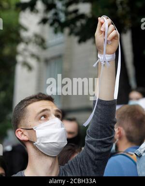 Ein Mann hält ein weißes Band während eines solidaritätsmarsches vor der Botschaft von Belarus.Belarussische Bürger, die in der Ukraine leben, Mitglieder von Amnesty International und ukrainische Aktivisten hielten eine Kundgebung zur Unterstützung der Belarussen ab, die gegen Wahlmanipulierung bei den Präsidentschaftswahlen protestierten, Forderung nach dem Recht auf Achtung der Redefreiheit und der Freiheit der friedlichen Versammlungsfreiheit. Stockfoto