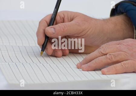 Alte Hände schreiben auf einem Blatt Stockfoto