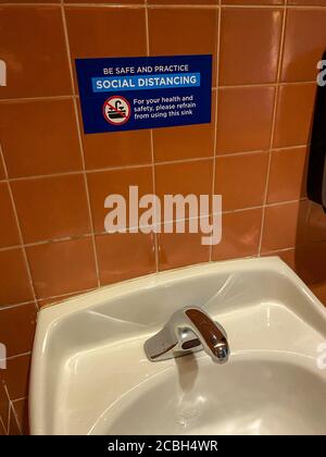 Orlando, FL/USA- 6/13/20: Ein Schild, das die Gäste der Universal Studios in Orlando, Florida auf soziale Distanz warnt und davon absieht, ein Waschbecken in einer Badewanne zu benutzen Stockfoto