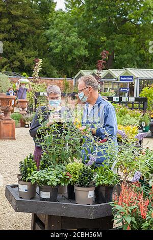 Paar Mann und Frau einkaufen im Freien in einem Gartencenter Tragen Gesichtsmasken Abdeckung Stockfoto