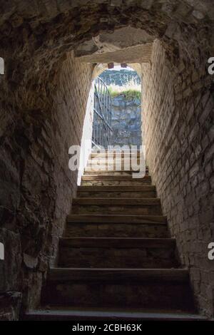 Der Blick auf die Ausgangstür am Ende eines dunklen alten Korridors im Schloss oder Herrenhaus. Stockfoto