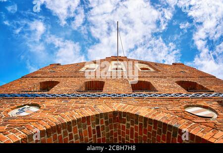 Historisches Backsteinstadttor unter blauem Himmel mit Wolken in der Hansestadt Wismar an der Ostsee. Stockfoto