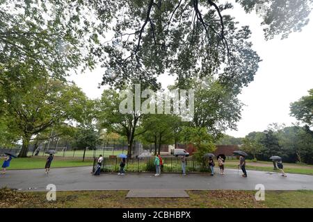 New York City, USA. August 2020. Die Menschen warten im Regen in langen Schlangen bis zu drei Stunden, um kostenlos COVID-19 Tests im Sunset Park, im Brooklyn Bezirk von New York City, NY, zu erhalten, 13. August 2020. New York City Bürgermeister Bill de Blasio kündigte "Hyper-lokale" Coronavirus-Tests als Reaktion auf. Höhere Infektionsraten und niedrige Testraten im Sunset Park Abschnitt von Brooklyn. (Anthony Behar/Sipa USA) Quelle: SIPA USA/Alamy Live News Stockfoto