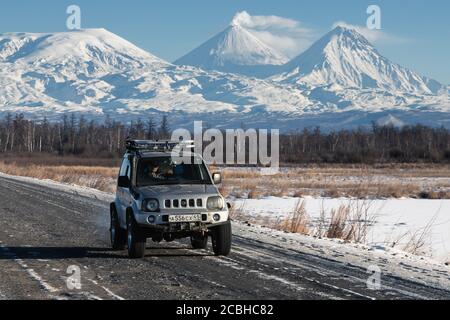 Japanische SUV Suzuki Jimny Fahren entlang der Straße auf dem Hintergrund schöne Winterlandschaft Reiseziele - aktiv Kluchevskoy Vulkan. Kamtschatka Stockfoto