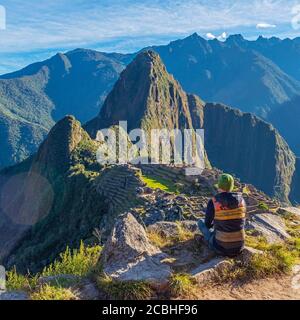 Touristen betrachten die Machu Picchu inka Ruine bei Sonnenaufgang nach der Inka Trail Wanderung in quadratischer Zusammensetzung, Cusco, Peru. Stockfoto