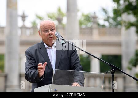 Potsdam, Deutschland. August 2020. Claus Peter Ladner, Vorsitzender des Fördervereins "Lindenstraße 54", spricht in der Glienicker Brücke zum Gedenken an den Mauerbau vor 59 Jahren. Im Hintergrund sieht man die Sandsteinkolonnaden, die die Brücke flankieren. Die Eisen-Stahl-Konstruktion über der Havel war während des Kalten Krieges eine symbolträchtige Schnittstelle zwischen Ost und West und war vor allem als Ort bekannt, an dem Agenten Autos austauschten. Quelle: Soeren Stache/dpa-Zentralbild/ZB/dpa/Alamy Live News Stockfoto