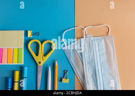 Anordnung der verschiedenen Schulbedarf.Schulbedarf, medizinische Masken. Schule Wiedereröffnung, Rückkehr in die Schule nach covid-19 Pandemie, neu Stockfoto