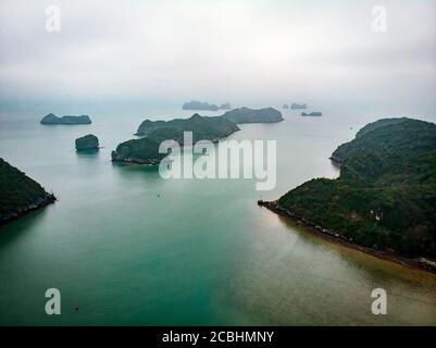 Schöne Aussicht auf Halong Bay von der Höhe. Draufsicht auf die Felsen, die aus ihrem Wasser ragen. nordvietnam. Meereslandschaft. Berge im Nebel Stockfoto