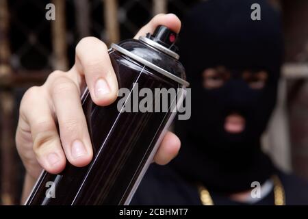 New York City, USA - 17. September 2013: Ein Mann in Balaclava hält Färbung Sprühflasche Stockfoto