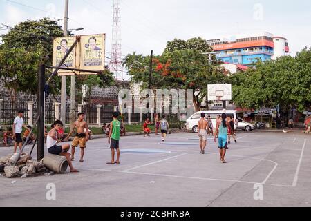 Cebu / Philippinen - 10. Juli 2019: Junge Filipinos spielen Basketball auf dem Straßenhof Stockfoto