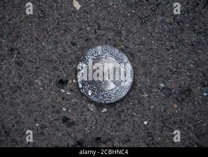 Berlin, Deutschland. August 2020. Auf einem Parkplatz eines Supermarkts in der Tiroler Straße in Pankow liegt ein verbranntes BMW-Emblem eines bei einem Brand heruntergefallenen Fahrzeugs. In der Nacht vom Freitag brannten vier Autos auf dem Parkplatz. Nach Angaben der Feuerwehr wurde niemand verletzt. Die Feuerwehr teilte mit, dass das Feuer Brandstiftung gewesen sein könnte. Es waren zunächst keine Details verfügbar. Quelle: Paul Zinken/dpa-Zentralbild/dpa/Alamy Live News Stockfoto