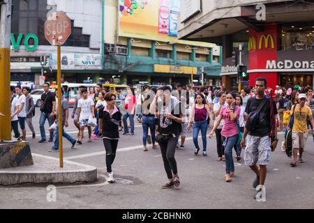 Cebu / Philippinen - 10. Juli 2019: Philippinische Menschen überqueren eine belebte Straße im Geschäftsviertel von Cebu Stockfoto