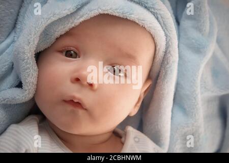 drei Monate altes Baby eingehüllt in blaue Decke Stockfoto