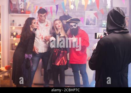 Rückansicht des grimmigen Schnabels, der ein Foto von Freunden auf der halloween-Party gemacht hat. Stockfoto