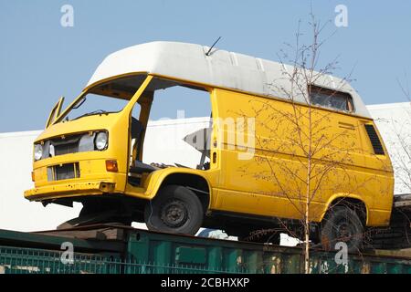 Gelber VW Bus Postbus auf Schrottplatz, Deutschland Stockfoto