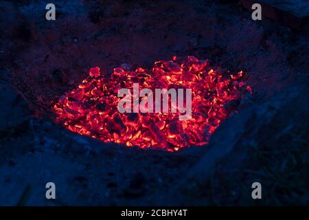 Glühend heiße Kohlen im Lagerfeuer - in der leuchtend Nacht Stockfoto