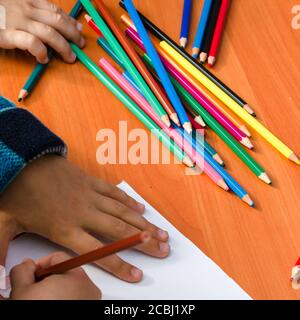 Die Handzeichnung des Kindes auf einem weißen Blatt Papier mit Buntstiften. Bildung, Freizeit und Kinder Aktivitäten Konzept. Nahaufnahme Stockfoto
