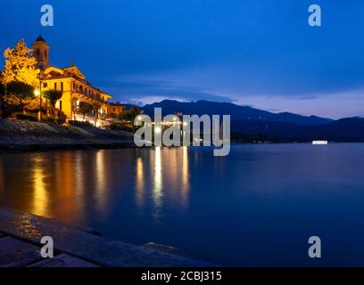 Stimmungsvolle Landschaft bei Dämmerung mit einem malerischen Dorf am See Maggiore, Italien Stockfoto