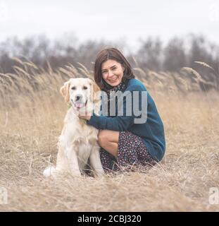 Fröhliche Frau mit hingebungsvollen Hund im Frühjahr Natur Stockfoto