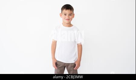 Niedlichen kleinen Jungen trägt blank weißes T-Shirt auf einem Weißer Hintergrund Stockfoto