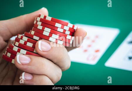 Poker-Chips in Frau Hand auf Spielkarten Hintergrund Stockfoto