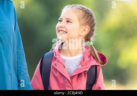 Portrait der Schule Mädchen suchen auf Mutter im Freien Stockfoto