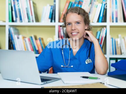 Lachende blonde Medizinstudentin bei der Arbeit im Krankenhaus Stockfoto