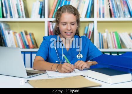 Junge blonde Medizinstudentin bei der Arbeit im Krankenhaus Stockfoto