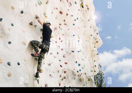 Outdoor Klettern Sport Aktivität Konzept : Mann Kletterer auf künstliche Kletterwand Stockfoto