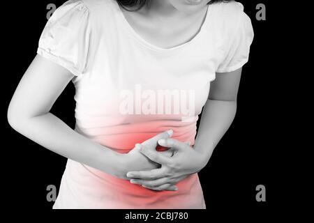 Frau leidet an Magenschmerzen oder Gastroenterologie. Konzept mit Gesundheitswesen und Medizin. Schmerzen in roter Farbe. Isolieren auf schwarzem Hintergrund durch Beschneiden Stockfoto