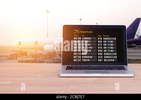 Technologie für komfortables Reisen, Tourist, Reisekonzept: Flugstatus auf Notebook, Laptop mit Flughafen und verwischen Flugzeug Hintergrund Stockfoto