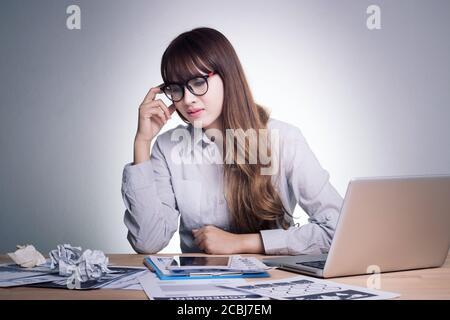 Krank fühlen, gestresst und müde. Stress junge Geschäftsfrau im erwerbsfähigen Alter arbeitet an ihrem Arbeitsplatz im Büro unter Druck Stockfoto