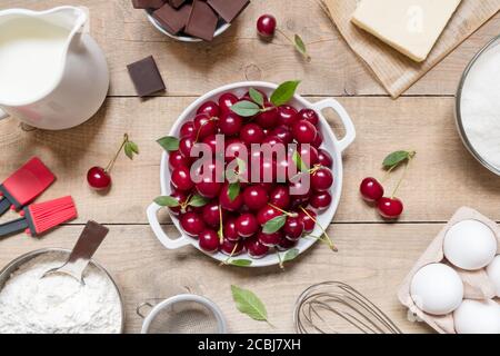 Draufsicht Rohzutaten zum Kochen von Kirschkuchen auf Holzhintergrund. Backwaren Hintergrund Stockfoto