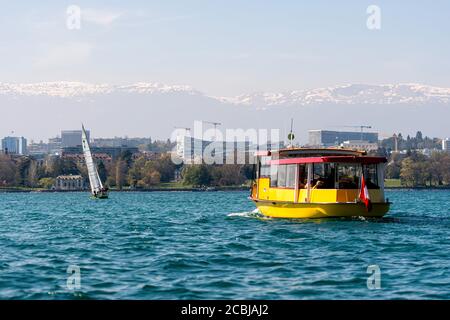 Genf, Schweiz - 14 April, 2019: Blick auf eine gelbe und rote Mouettes Genevoises Navigation Boot, eine öffentliche Verkehrsmittel Boot unterwegs über den See Stockfoto