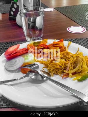 Reisnudeln mit Karotte, Paprika und Zwiebel auf weißem Teller Stockfoto