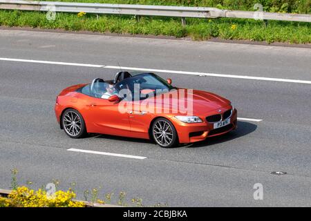 2013 orange BMW Z4 sDrive 20I M Sport Auto; Fahrzeugverkehr Fahrzeuge, die Fahrzeuge auf britischen Straßen fahren, Motoren, die auf dem Autobahnnetz der Autobahn M6 fahren. Stockfoto