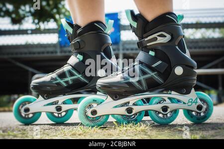 Weibliche Beine in Inline-Rollschuhe Nahaufnahme in Aktion. Extremsport. Konzept über Sport und Freizeit. Sportlicher Lifestyle. Spaß mit Aktivitäten Stockfoto