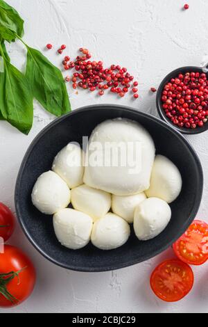 Mozzarella Käse in schwarzer Schüssel, Basilikum Tomate Kirsche balsamisch schwarzen Schiefer Stein Kopie Raum. Zutaten für Caprese Salat auf weißem Hintergrund close up Stockfoto