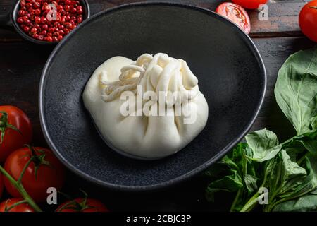 Buffalo Burrata Käse auf schwarzem Teller serviert. Nahaufnahme mit dunklem Hintergrund, selektiver Fokus Stockfoto
