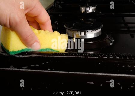 Gasherd mit Waschmittel und einem Waschlappen aus nächster Nähe waschen. Stockfoto