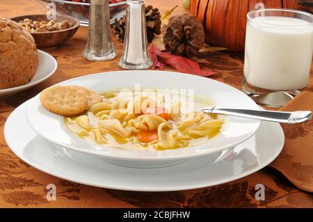 Pute- oder Hühnernudelsuppe mit Crackern und Brötchen Stockfoto