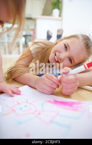 Zwei lachende Mädchen malen im Kindergarten ein Bild Stockfoto